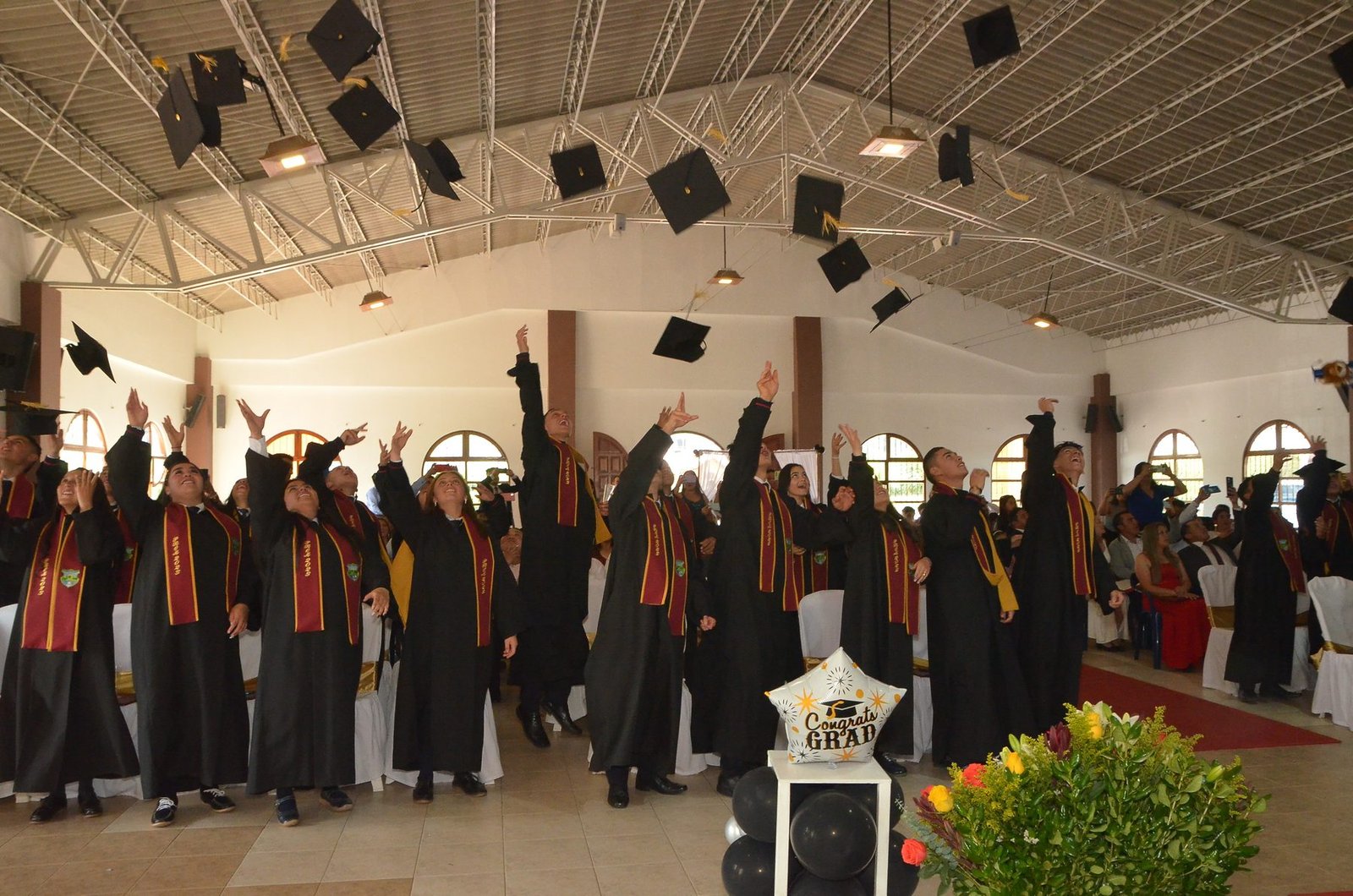 Graduandos lanzando birretes al aire